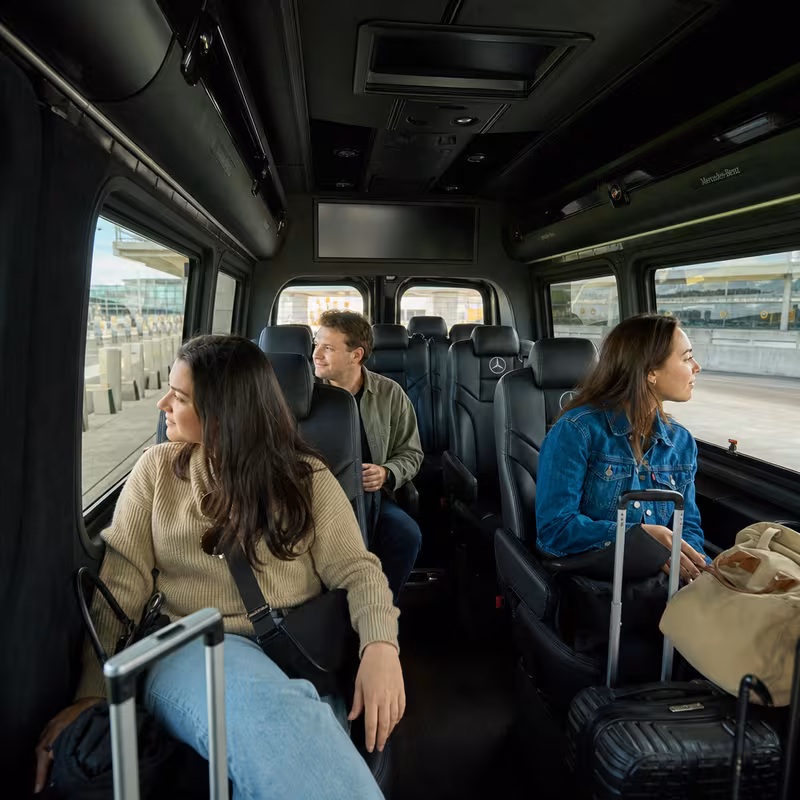 Passengers loading luggage while boarding an Oakland group shuttle
