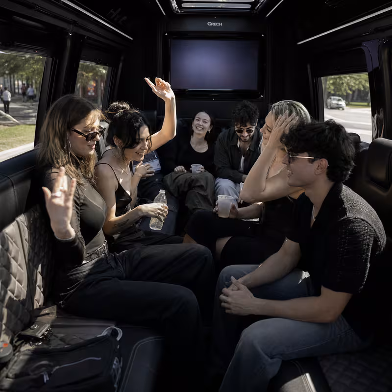 Group boarding a white charter bus for Concert Transportation transportation in Oakland
