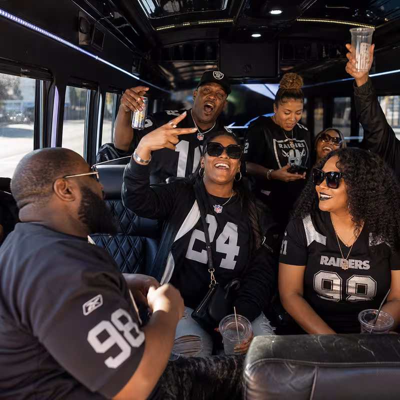Group boarding a white charter bus for Sporting Event Transportation transportation in Oakland