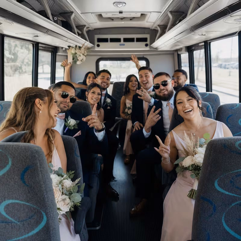 Group boarding a white charter bus for Wedding Transportation transportation in Oakland