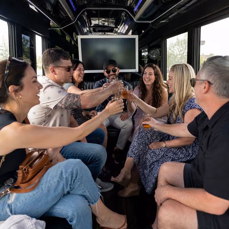 Group boarding a white charter bus for Winery & Brewery Tour Transportation transportation in Oakland